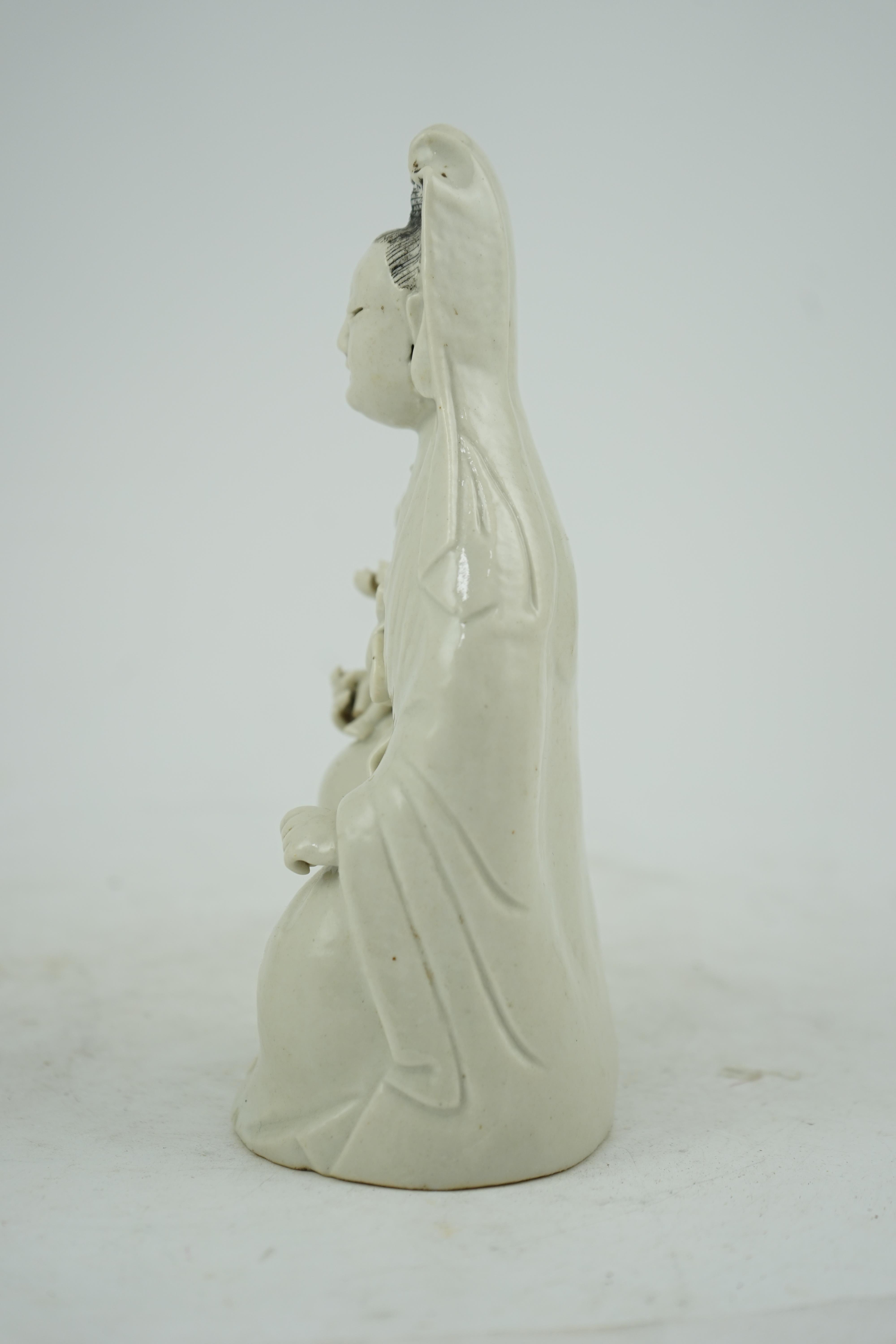 A Chinese white glazed group of Guanyin and child, 18th/19th century